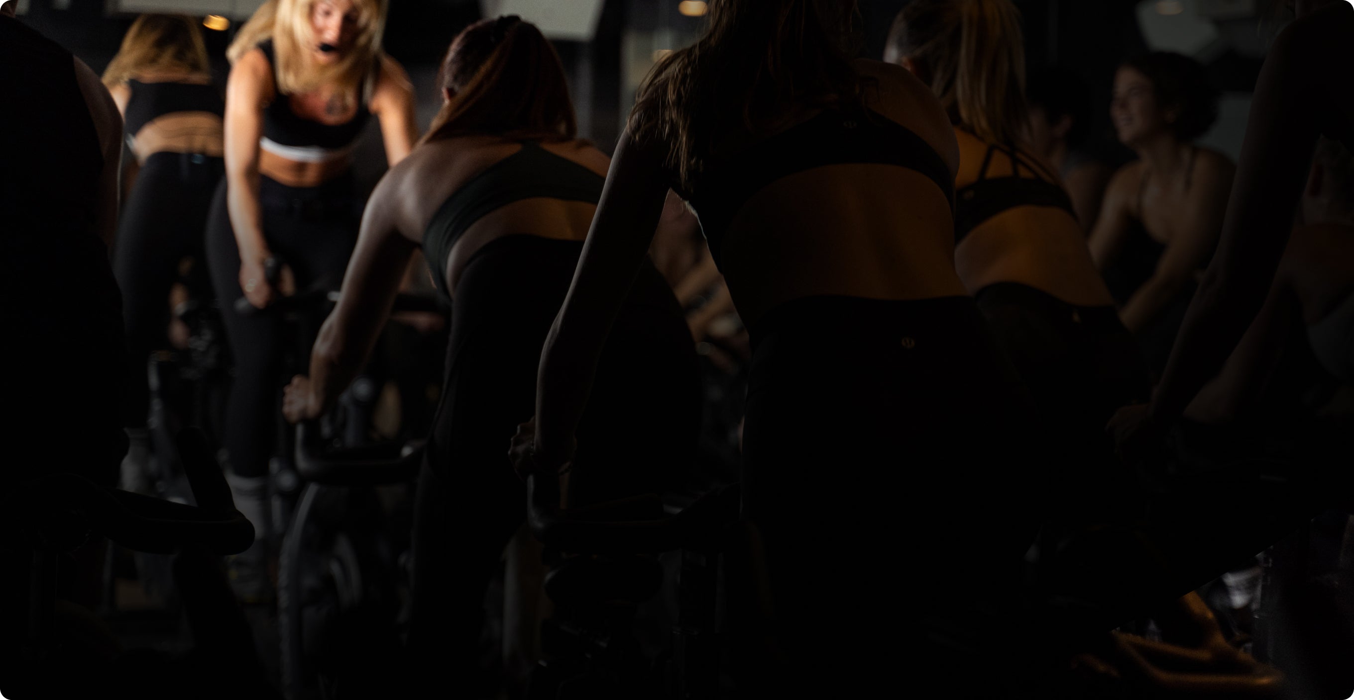 Group of people on indoor stationary bikes in a gym