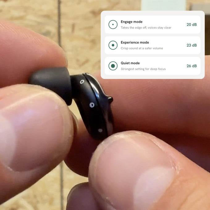 Close up of person holding Loop Switch 2, with text info about the 3 modes available on Loop Switch 2:
- Engage Mode - Takes the edge off, voices stay clear - 20dB
- Experience mode - Crips sound at a safer volume - 23dB
- Quiet mode - Strongest setting for deep focus - 26dB