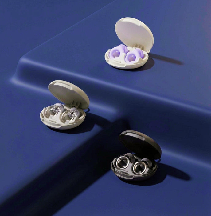 Three open cases on a blue surface, containing Loop Quiet 2, Loop Engage and Loop Experience earplugs.