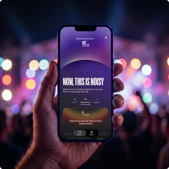Hand holding a smartphone with a noise level app displayed, against a blurred concert background.