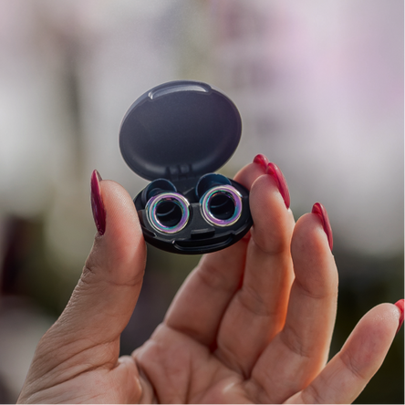 Hand holding open black case with Tomorrowland x Loop Switch 2 earplugs against a blurred background