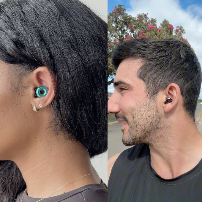 A split-screen lifestyle image showing two people wearing Loop Switch 2. The left side shows a close-up of a woman's ear with the Emerald version in-ear, and the right side shows a man in profile wearing the black version outdoors.